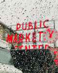 Seattle Public Market sign viewed through a rain-covered window