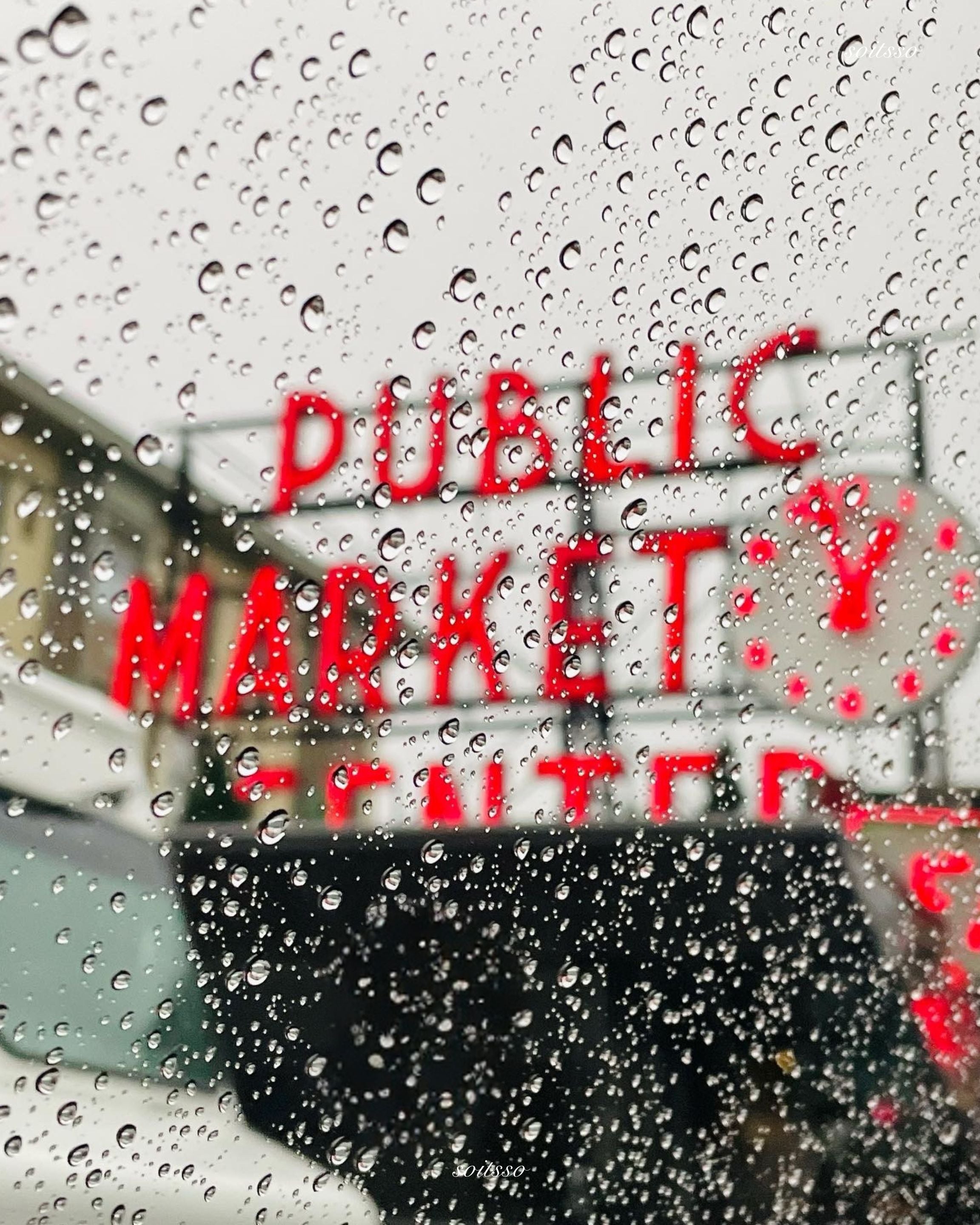 Seattle Public Market sign viewed through a rain-covered window